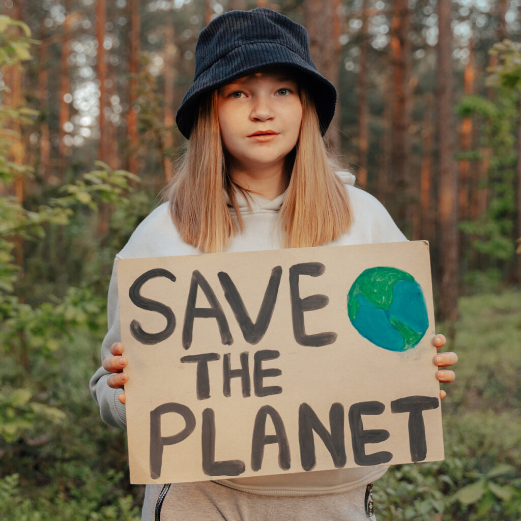 Young girl holding a "Save the Planet" sign - Learn about Blue Mountain Worms Green Guardians.